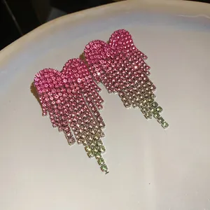 Detailed close-up of sparkling heart tassel earrings with pink to green rhinestone gradient