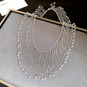 Close-up detail of elegant silver fringe necklace with crystal beads on gray display