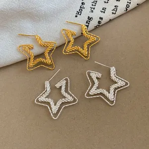 Exquisite close-up of 18k gold and silver plated star stud earrings with textured design