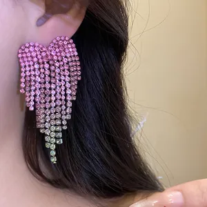 Close-up view of elegant pink rhinestone heart tassel earrings worn on ear for women
