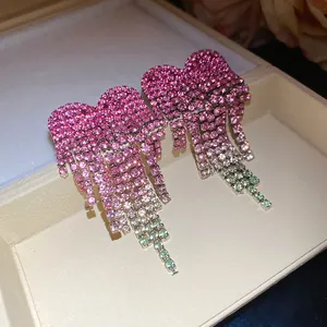 Close-up detail of elegant pink heart-shaped rhinestone tassel drop earrings in a box