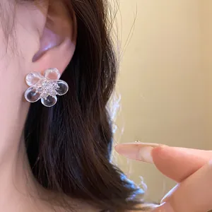 Close-up of sweet resin flower stud earring with sparkling cubic zirconia center.