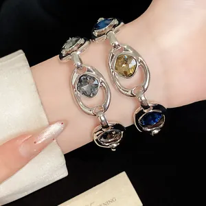 Détail rapproché de bracelets à maillons ovales vintage avec pierres précieuses au poignet