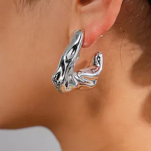Detailed macro view of irregular silver liquid metal hoop earring with crumpled texture