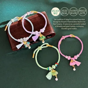 Detailed view of handmade braided five-color rope bracelets with brocade triangle charms