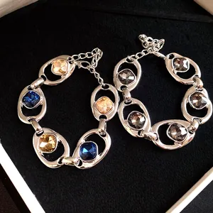 Vue détaillée de bracelets ovales évidés avec strass étincelants bleus et dorés