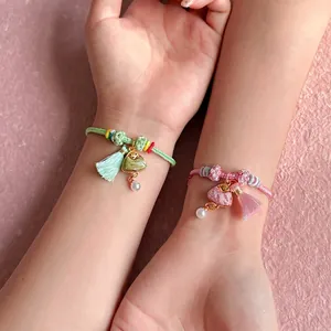 Detail of handmade woven bracelets with Zongzi charms and colorful threads for Duanwu.
