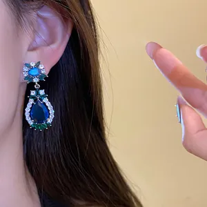 Nahaufnahme von blauen Zirkon-Ohrhängern im Vintage-Stil mit elegantem Blumendesign