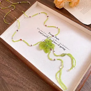 Handmade green crystal beaded necklace featuring a dainty flower pendant design