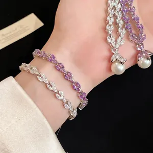 Elegant silver-tone zircon and pearl bracelet set with delicate leaf pattern charms.