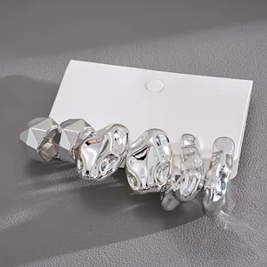 Set of six irregular geometric silver metallic stud earrings on white display card