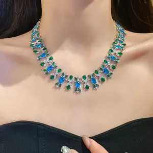 Nahaufnahme einer Vintage-Zirkon-Blumenkette mit blauen und grünen Steinen an einem Modell.