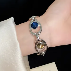 Gros plan d'un bracelet vintage en argent avec cristaux bleus et ambrés au poignet