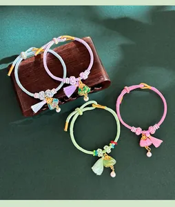 Detail of handmade woven Songjin triangle charm bracelets with tassels and pearls.