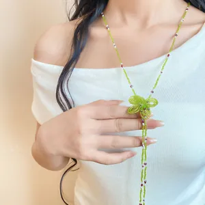 Detailed view of a handmade green crystal beaded flower necklace worn by a model