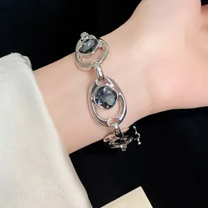 Gros plan d'un bracelet rétro évidé avec pierres gris foncé au poignet