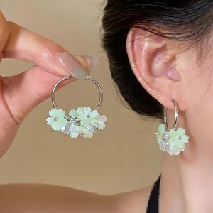 Close-up of sweet resin flower hoop earrings with mint green petals and silver hoop.