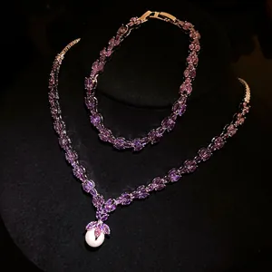 Close-up of elegant purple marquise zirconia jewelry set with a white pearl pendant detail
