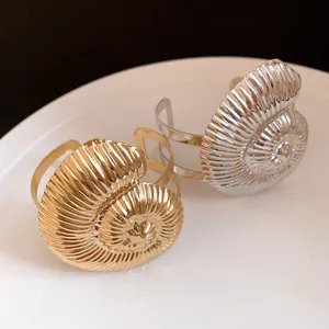 Vue détaillée de bracelets ouverts en métal plissé en forme de coquillage doré et argenté