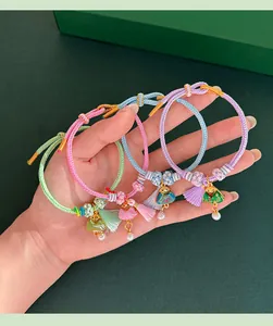 Close-up of four handmade colorful braided bracelets with silk tassels and charms.