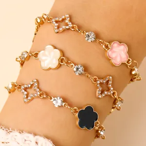 Gros plan de bracelets dorés ornés d'étoiles en strass et de trèfles émaillés colorés
