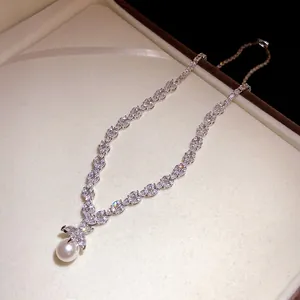 Elegant zircon leaf necklace with a round white pearl pendant in a luxury gift box.
