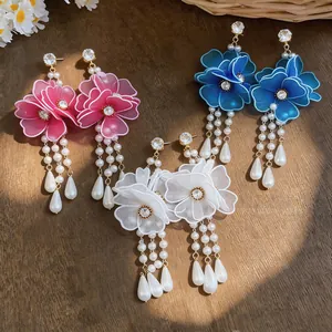 Detailed view of resort-style mesh flower earrings with pearl tassels in three colors.