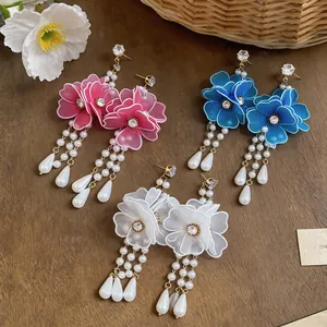 Detailed view of elegant mesh flower earrings with dangling pearls in three colors