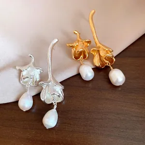 Elegant floral drop earrings with lustrous freshwater pearls in gold and silver finishes.