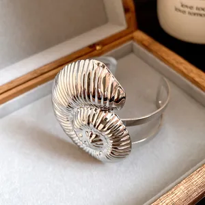 Vue détaillée d'un bracelet manchette en coquillage argenté dans une boîte
