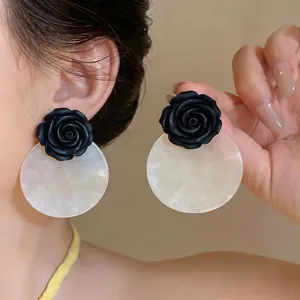Elegant black rose resin earrings with white acrylic disks for a stylish beach vacation look.