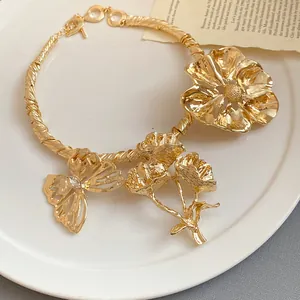 Detail der goldenen Halskette im Vintage-Palaststil mit Blumen- und Schmetterlingsmotiv.