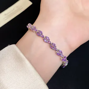 Close-up detail of an elegant silver bracelet featuring sparkling purple marquise-cut zircons