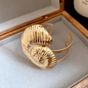 Vue détaillée d'un bracelet manchette ouvert doré avec texture coquillage pour femmes