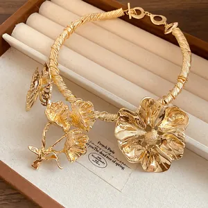 Detailansicht des verzierten goldfarbenen Halsreifens mit Blumen- und Schmetterlingsmotiv.