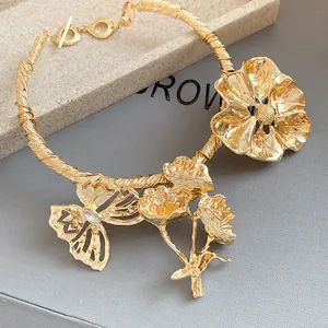 Detailansicht eines goldfarbenen Kropfbandes mit Blumen- und Schmetterlingsdekor
