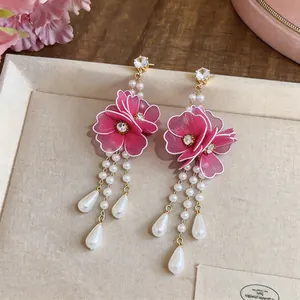 Exquisite close-up of pink silk mesh flower earrings with elegant long pearl tassels