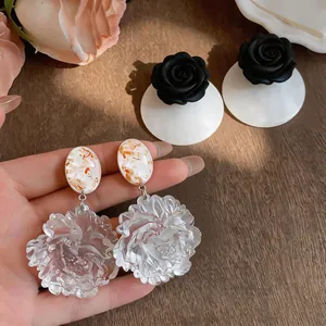 Detailed shot of resin floral pendant earrings featuring intricate translucent petal textures