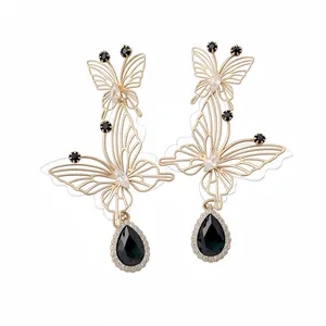 Elegante goldfarbene Schmetterlingsohrringe mit schwarzen Tropfen und Zirkonia-Steinen.