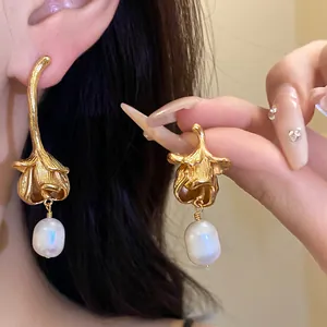Close-up of vintage gold flower earrings with elegant freshwater pearl pendants