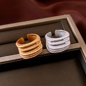 Close-up detail of vintage multi-layer threaded rings in gold and silver finish