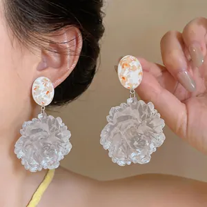 Macro view of resin flower earrings for vacation featuring white oval floral studs.