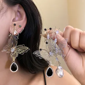 Detailansicht eleganter Schmetterling-Ohrringe mit schwarzem Tropfen und Perle