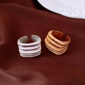 Detailed macro view of vintage gold and silver multi-layer ribbed textured open rings.
