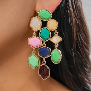 Close-up detail of vibrant colorful geometric resin tassel earrings worn on a model ear
