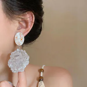 Detail view of large translucent resin flower pendant earrings for beach vacation