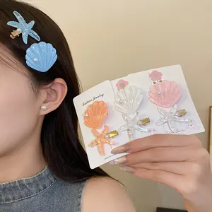 Detailed view of resin starfish and shell hair clips worn by a model