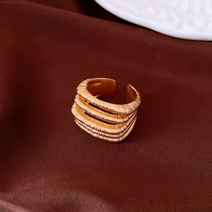 Close-up of a vintage gold-toned multi-layer ribbed open ring on a silk background.