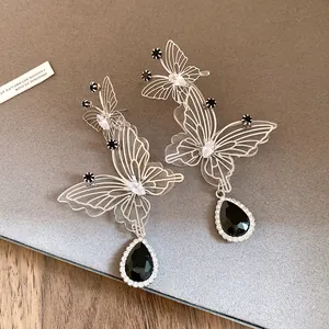 Detailansicht modischer Hohl-Schmetterling-Ohrringe mit schwarzen Tropfen-Zirkonia-Steinen.