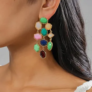 Detail shot showing vibrant dopamine geometric resin tassel earrings worn by a model